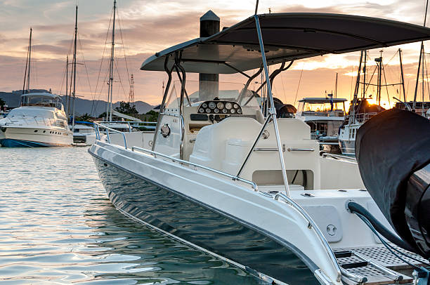 Small motorboat docking at the marina at sunset time Small motorboat docking at the marina with sunset in Phuket Thailand small boat stock pictures, royalty-free photos & images