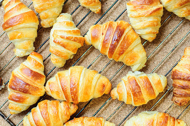 istock Fresh baked croissants on metallic rack 474612424