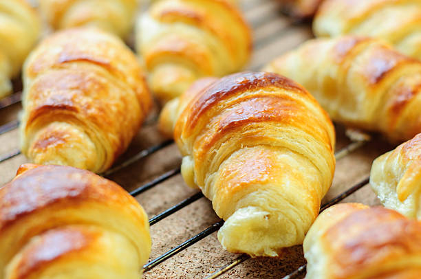 istock Fresh baked croissants on metallic rack 474612496
