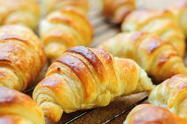 istock Fresh baked croissants on metallic rack 474612560