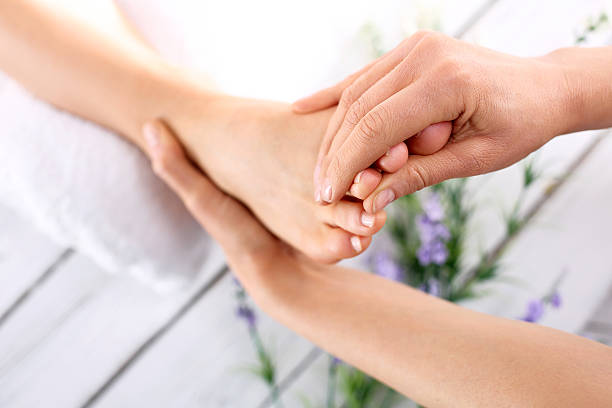massagem nos pés - reflexology pedicure massaging human foot imagens e fotografias de stock