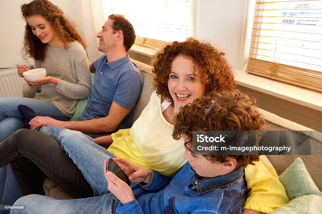 Happy family sitting on sofa enjoying tim together Portrait of a happy family sitting on sofa enjoying tim together 2015 Stock Photo