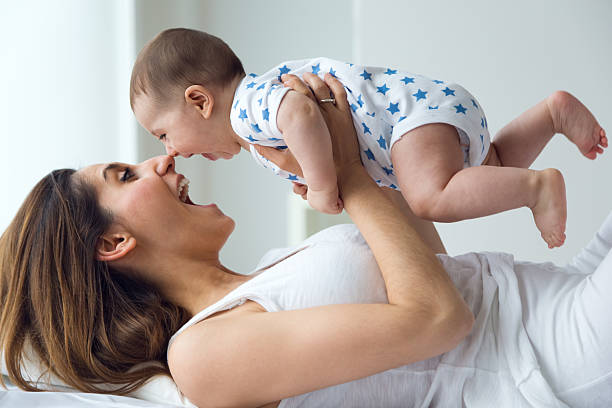 istock Mother and baby playing and smiling at home. 474617536