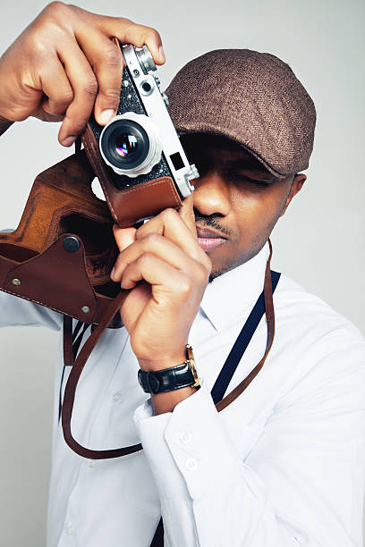 Portrait of a stylish young man with old photocamera