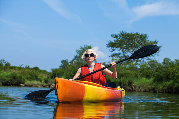 istock Woman With Safety Vest Kayaking Alone on a Calm River 474618183