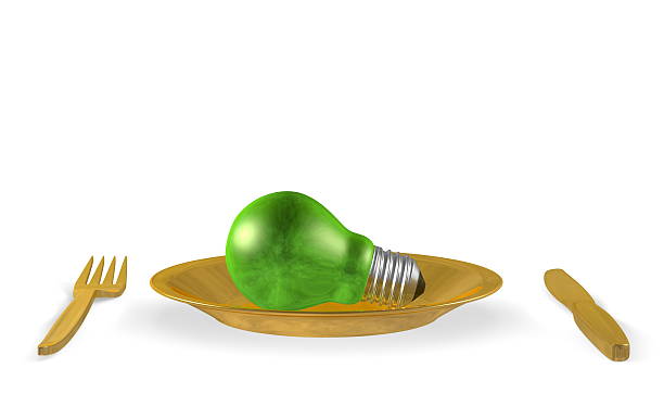 istock Green light bulb, golden plate, fork and knife. Front view 474619493