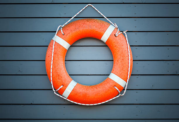 istock Red lifebuoy hanging on blue wooden wall 474619830
