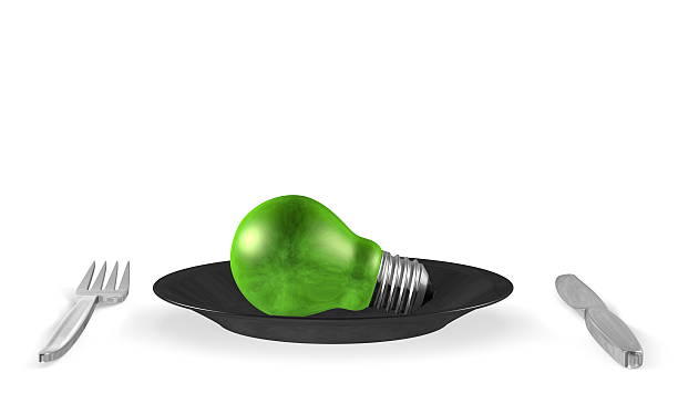 istock Green light bulb, black plate and steel cutlery. Front view 474619837