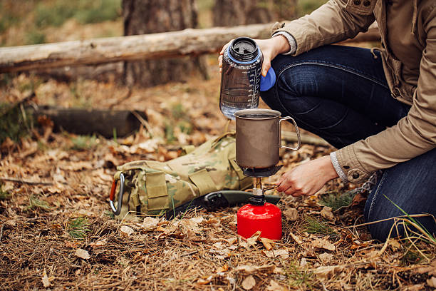 istock woman pours water from a bottle into a mug 474622920