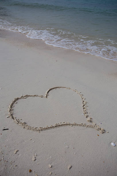 istock hearts drawn on the sand of a beach 474623536