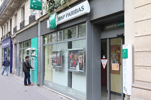 Paris, France - July 23, 2011: Person visits BNP Paribas Bank branch in Paris, France. Formed through merger in 2000, the bank is currently largest worldwide by assets ($2.68 trillion USD).