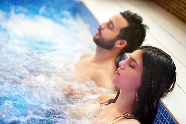 par relajars'en el jacuzzi. - spa treatment health spa couple happiness fotografías e imágenes de stock