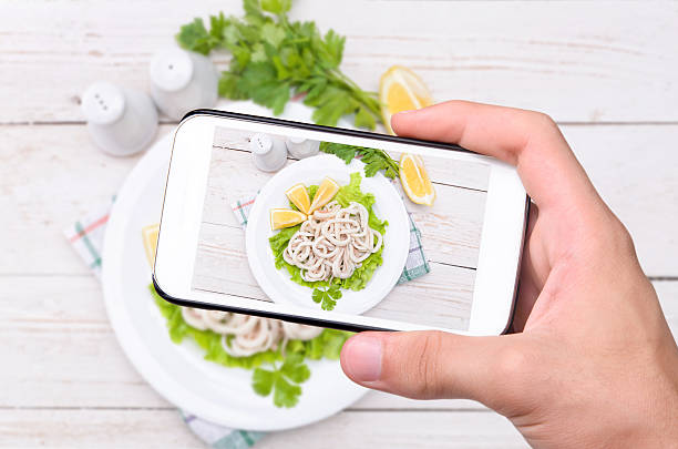 istock Hands taking photo squids & lemon with smartphone. 474624756