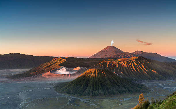 Sunrise at the Bromo volcano mountain in Indonesia Early morning view of the Bromo caldeira in East Java in Indonesia. The volcanic formation of a few volcanoes, with the famous volcano Bromo and the Semeru volcano in the background attract everyday large crowds of visitors on the mountain top for sunrise. bromo tengger semeru national park stock pictures, royalty-free photos & images