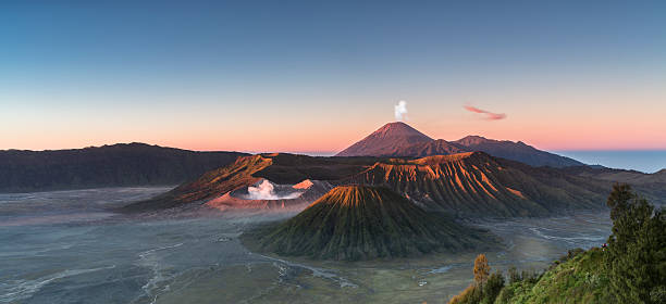 Sunrise at the Bromo volcano mountain in Indonesia Early morning view of the Bromo caldeira in East Java in Indonesia. The volcanic formation of a few volcanoes, with the famous volcano Bromo and the Semeru volcano in the background attract everyday large crowds of visitors on the mountain top for sunrise. bromo tengger semeru national park stock pictures, royalty-free photos & images