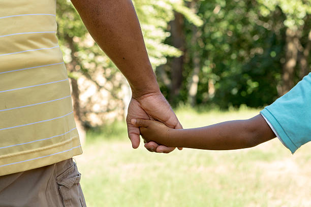 Father and son African American Father and son spending time together. kid holding fathers hand stock pictures, royalty-free photos & images