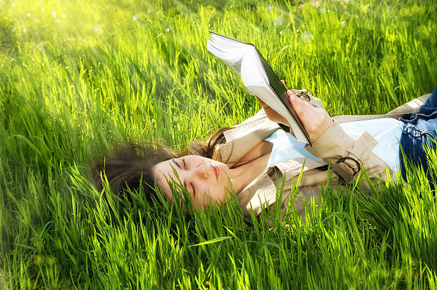 istock beautiful young woman  reading book in park 474631708