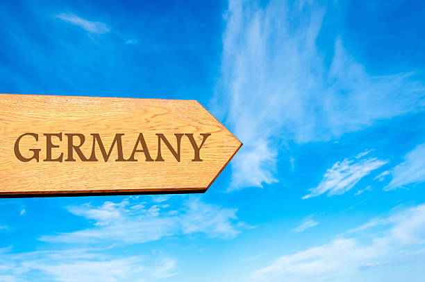 Wooden arrow sign pointing destination GERMANY against clear blue sky with copy space available. Travel destination conceptual image
