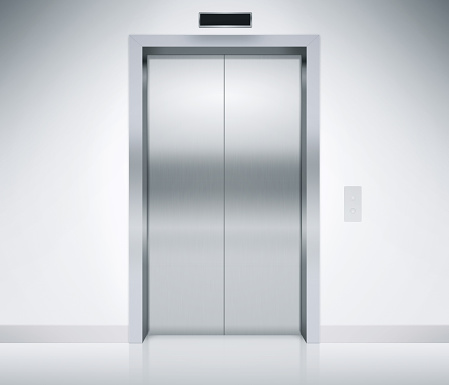 Modern elevator or lift doors made of metal closed in building with lighting.
