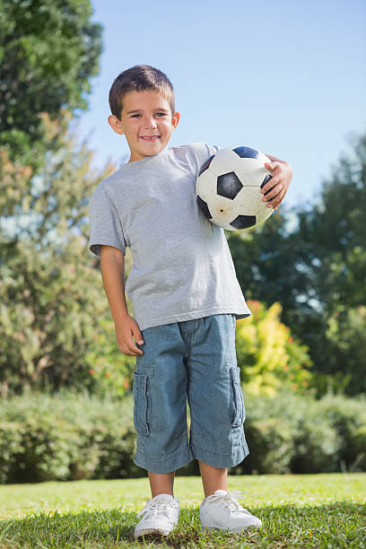 istock Young boy holding football 474641082