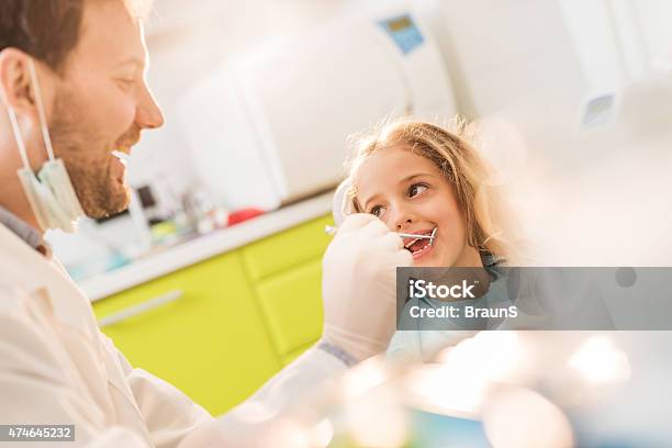 Glücklich Männlich Zahnarzt Untersuchen Kleine Mädchen Putzen In Zahnarztbüro Stockfoto und mehr Bilder von Kind
