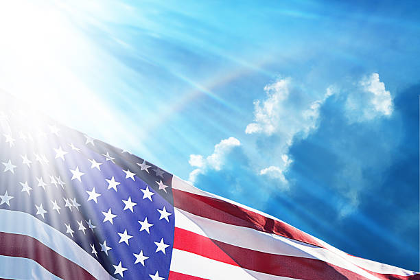 istock American Flag Under Blue Sky With Rainbow 474645508