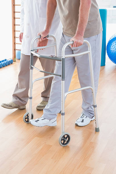 istock Senior man on zimmer frame with therapist 474645772