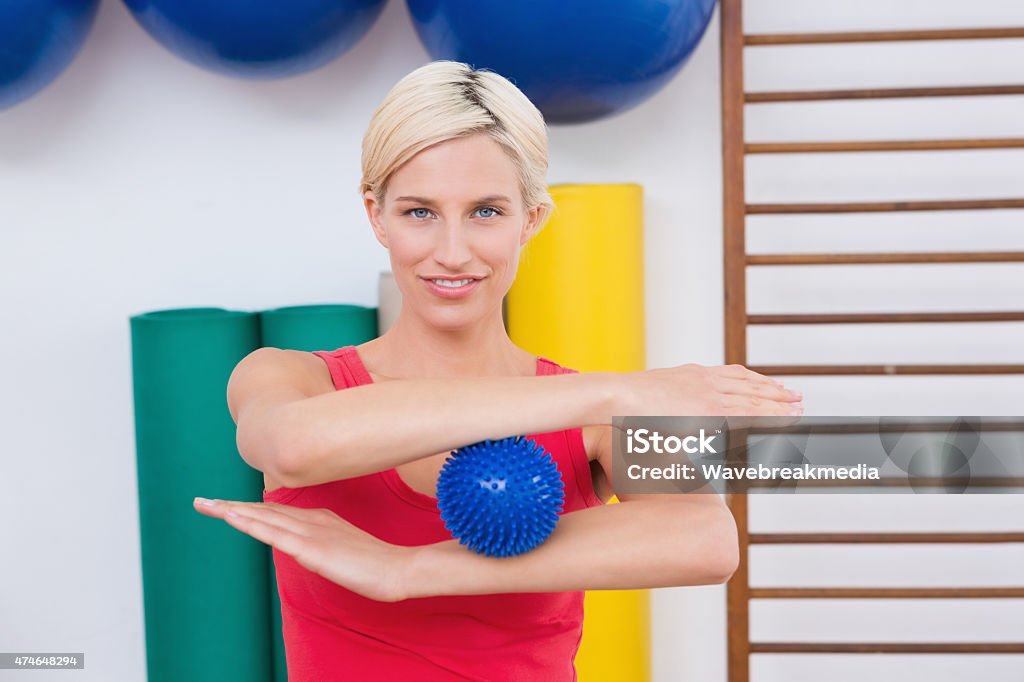 Blonde woman with massage ball Blonde woman with massage ball in fitness studio  20-29 Years Stock Photo