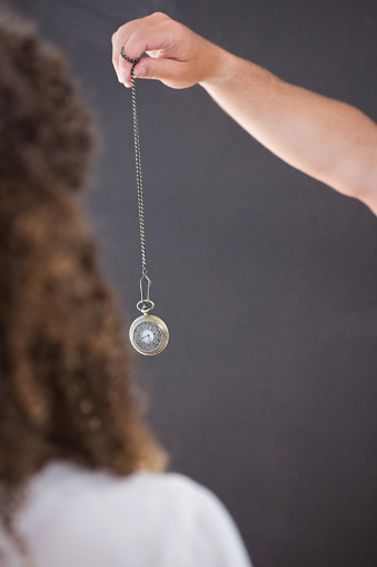 Woman being hypnotized with pendulum 