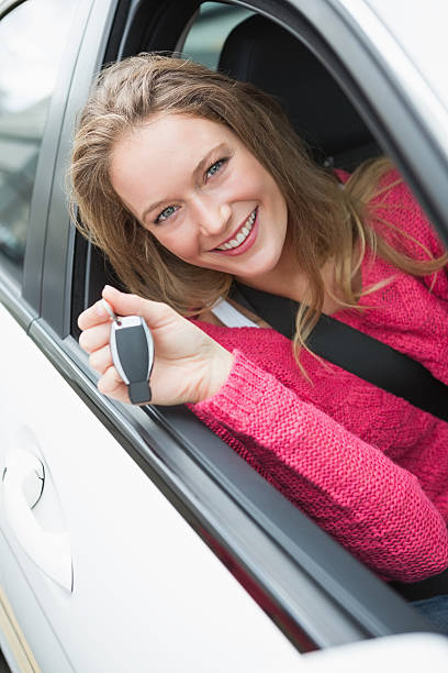 istock Young woman smiling and holding key 474652832