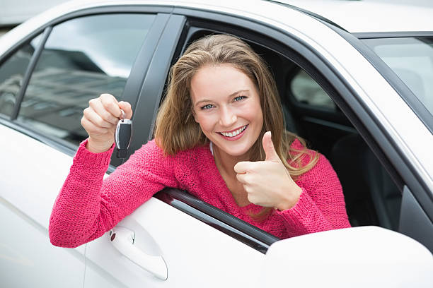 istock Young woman smiling and holding key 474652850