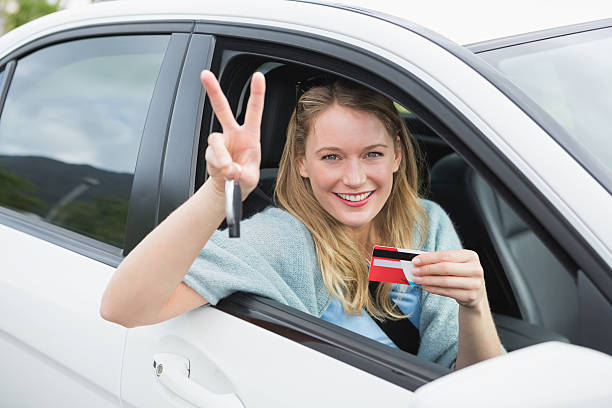 istock Young woman smiling and holding card 474652916