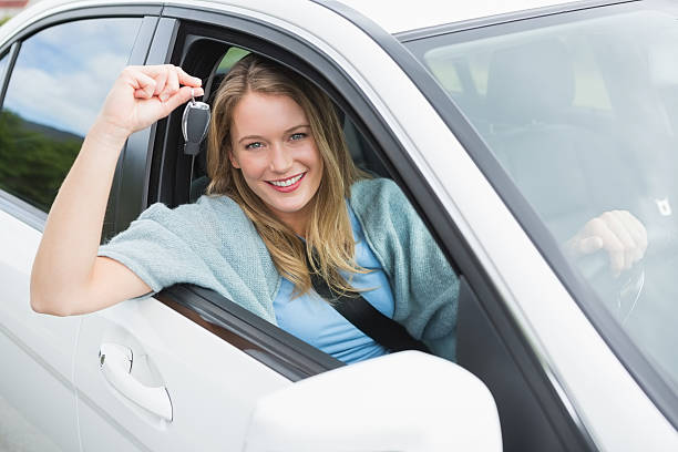 istock Young woman smiling and holding key 474652930