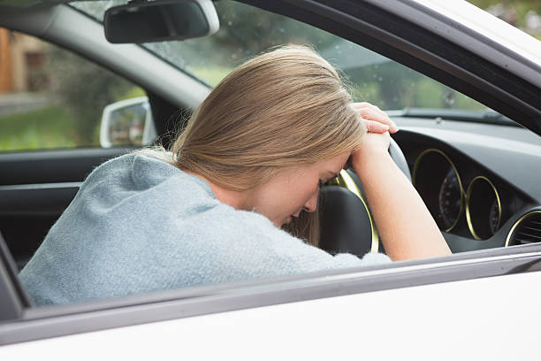 istock Tired woman asleep on steering wheel 474652974