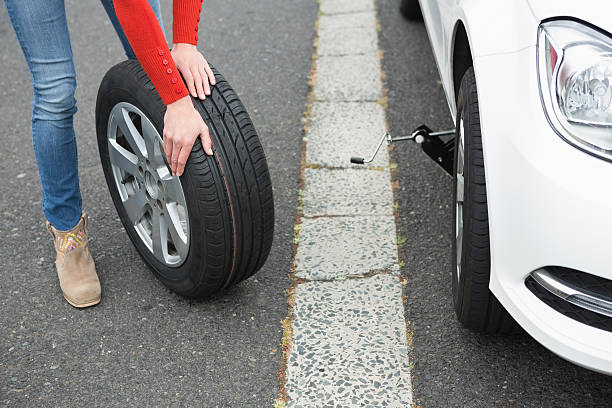 istock Woman replacing tire 474653312