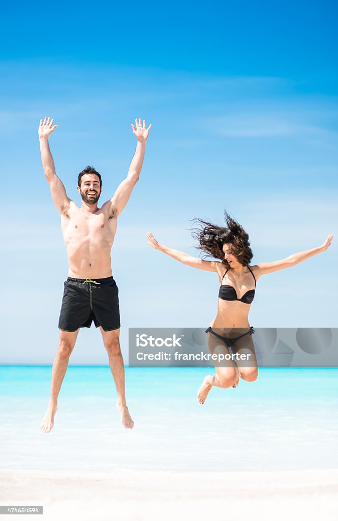 Happiness couple at the seaside jumping on the beach Exercising Stock Photo