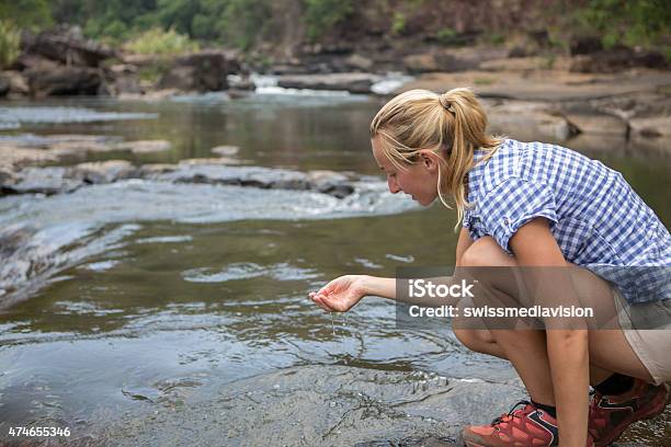 Woman Hiking Refreshing At River Stock Photo - Download Image Now - 20-29 Years, 2015, Adult