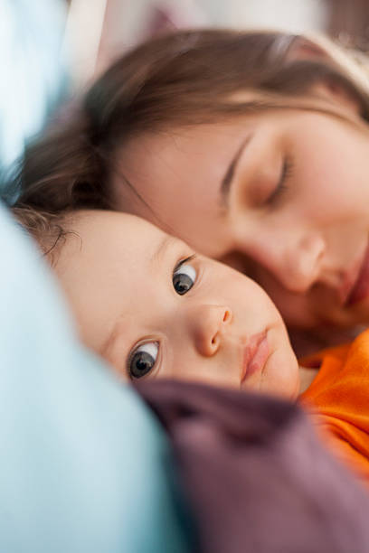istock Awake Baby Boy With Sleeping Mom In Bed 474657578