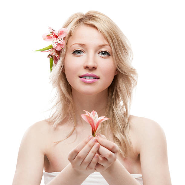 Close-up partial view of elegant blonde woman holding white flower, skincare concept