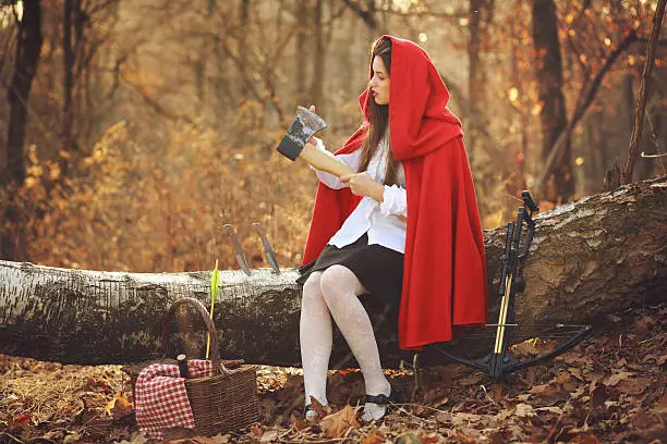 Little red riding hood checking her axe before the wolf hunt