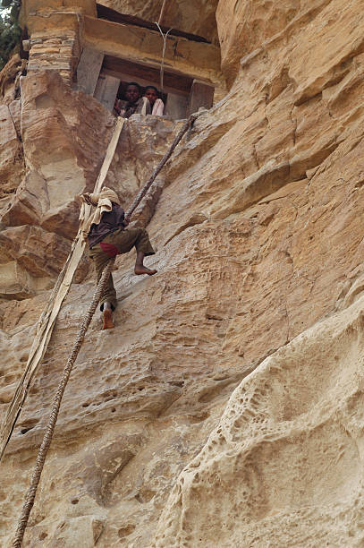 Debra Damo, Ethiopia - September 23, 2006:  Men climbing a rock with a camel leather rope to reach the enterance of the Debre Damo church in Northern Ethiopia.