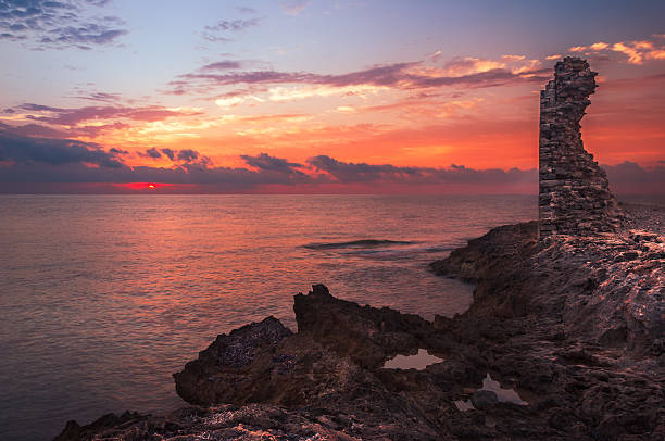 istock Sunset over the Sea and Rocky Coast with Ancient Ruins 474674341