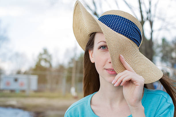 istock Freckled girl covering one eye by hat 474680058