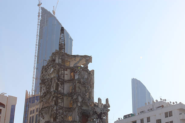 Close up of the modern skyscrapers of Abu Dhabi, in the United Arab Emirates, with an older building situated in the center of the modern buildings being demolished in order to construct newer, grander skyscrapers