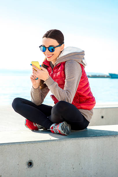 sport frau auf die promenade - women sweater vest beach pier stock-fotos und bilder