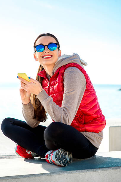 sport frau auf die promenade - women sweater vest beach pier stock-fotos und bilder