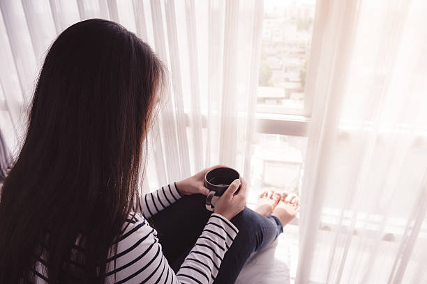 istock female hands holding coffeecup on bed 474695456