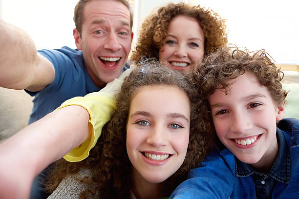 familia feliz tomando un autorretrato juntos - women sofa teenage girls hairstyle fotografías e imágenes de stock