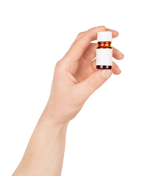 istock Man hand with small bottle isolated on white background 474700034