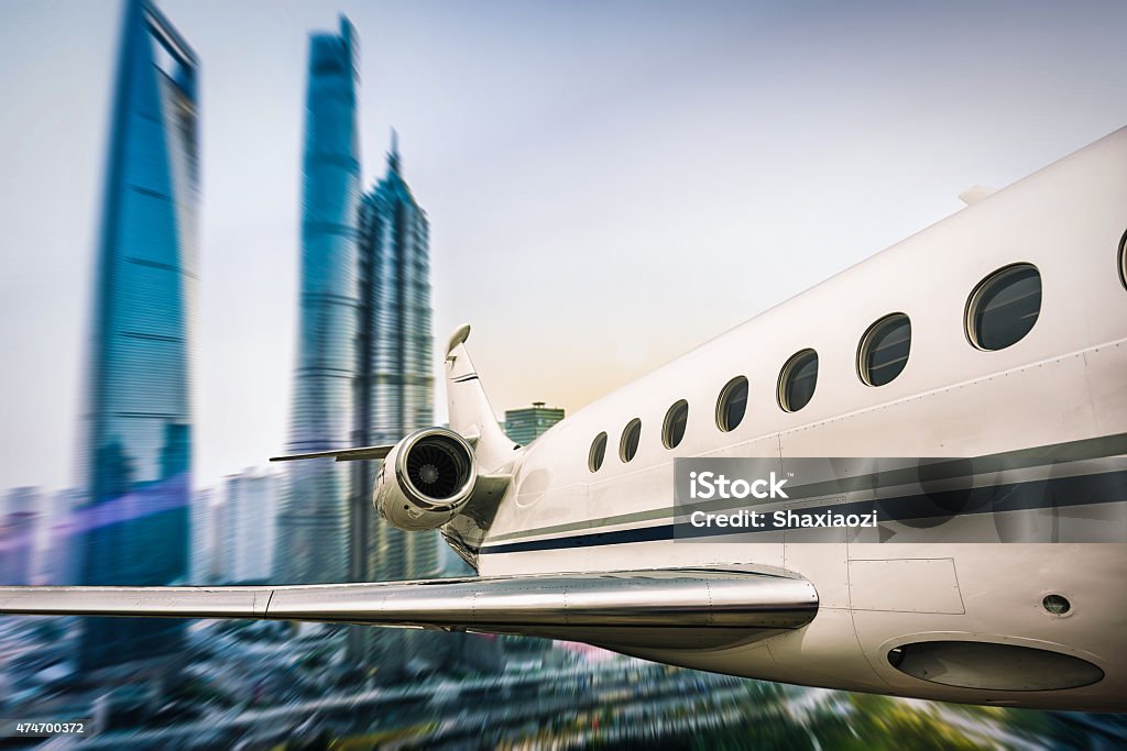 flying airplane above city a moving airplane is flying over a city. 2015 Stock Photo